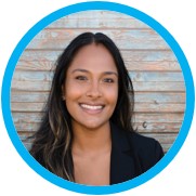 Smiling woman in front of wooden background.